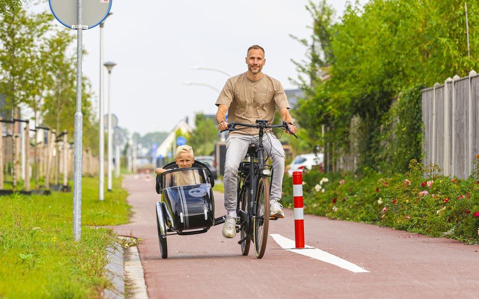 Vader op fiets met zoon in fietszijspan